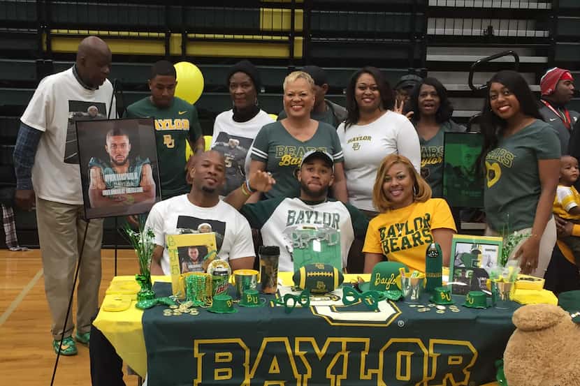 DeSoto defensive back Byron Hanspard Jr. was surrounded by his family at the school's...