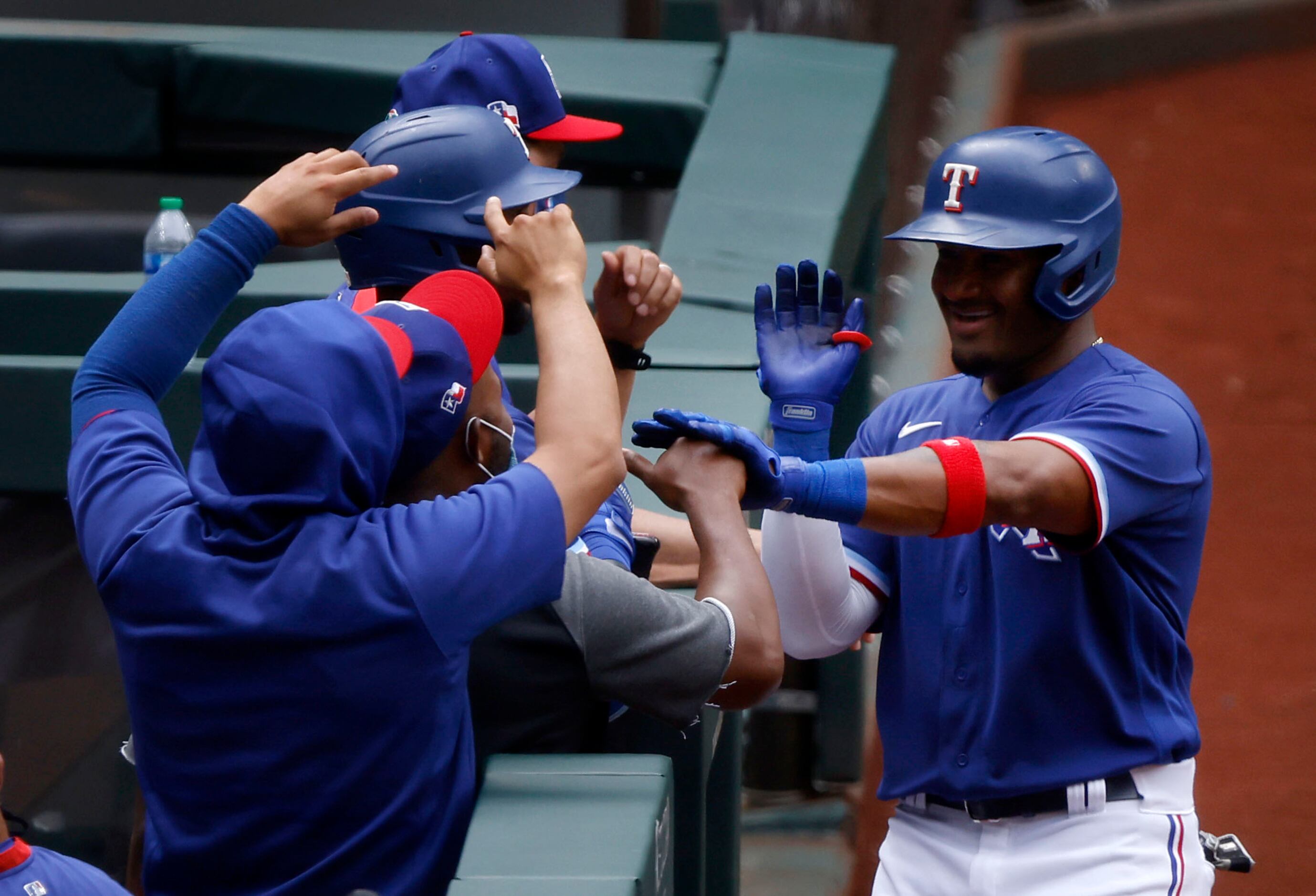 Texas Rangers batter Andy Ibáñez is greeted by teammates after hitting a solo home run in...