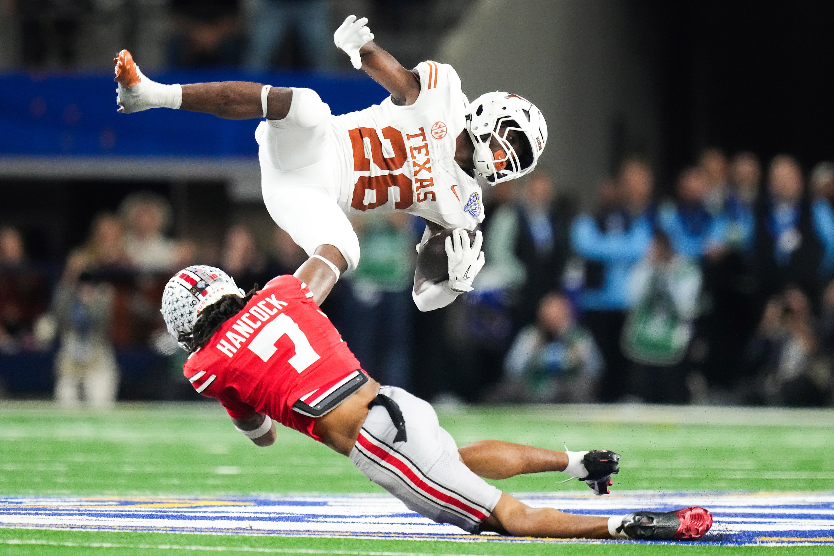 Texas running back Quintrevion Wisner (26) is upended by Ohio State cornerback Jordan...