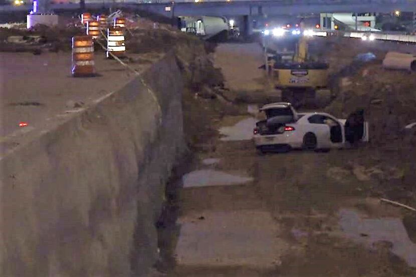 A Dodge Charger lies wrecked in a construction area along Interstate 30 in Arlington on...