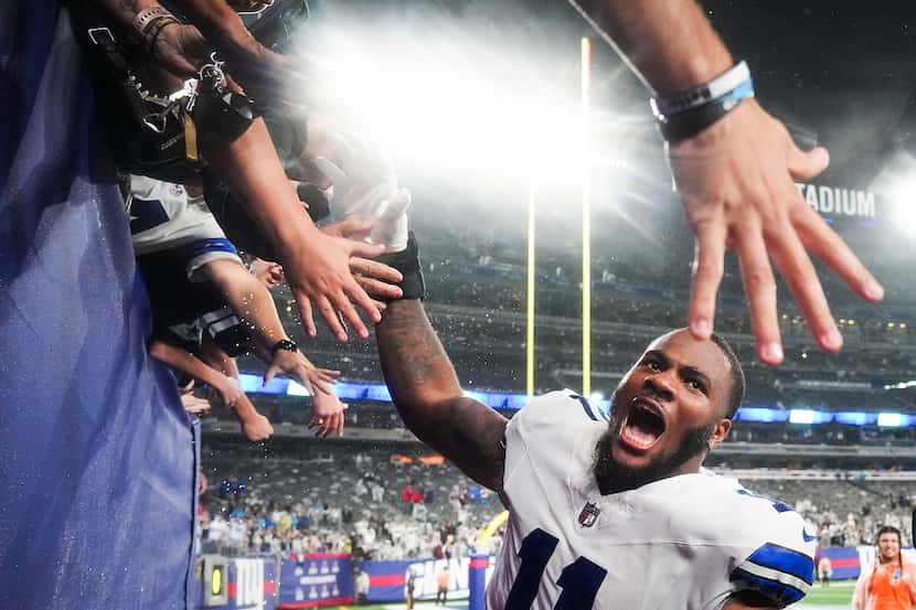 Dallas Cowboys linebacker Micah Parsons celebrates with fans as he leaves the field after a...