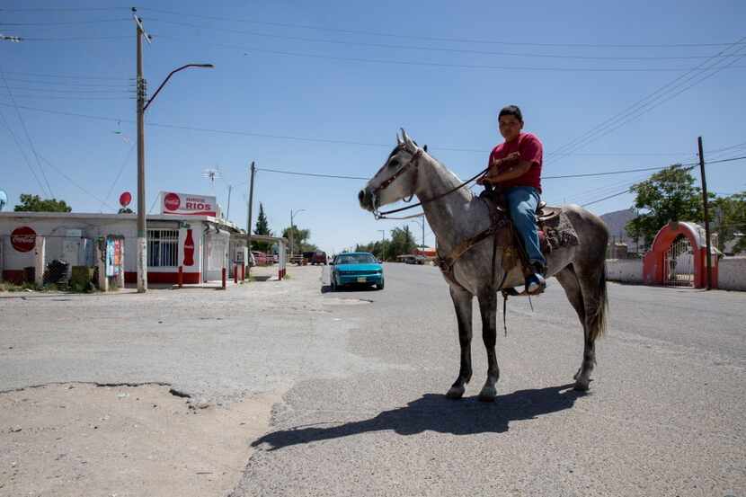  Jesus Martinez Velador Castro, 12, rides a horse down the street in Samalayuca, near where...