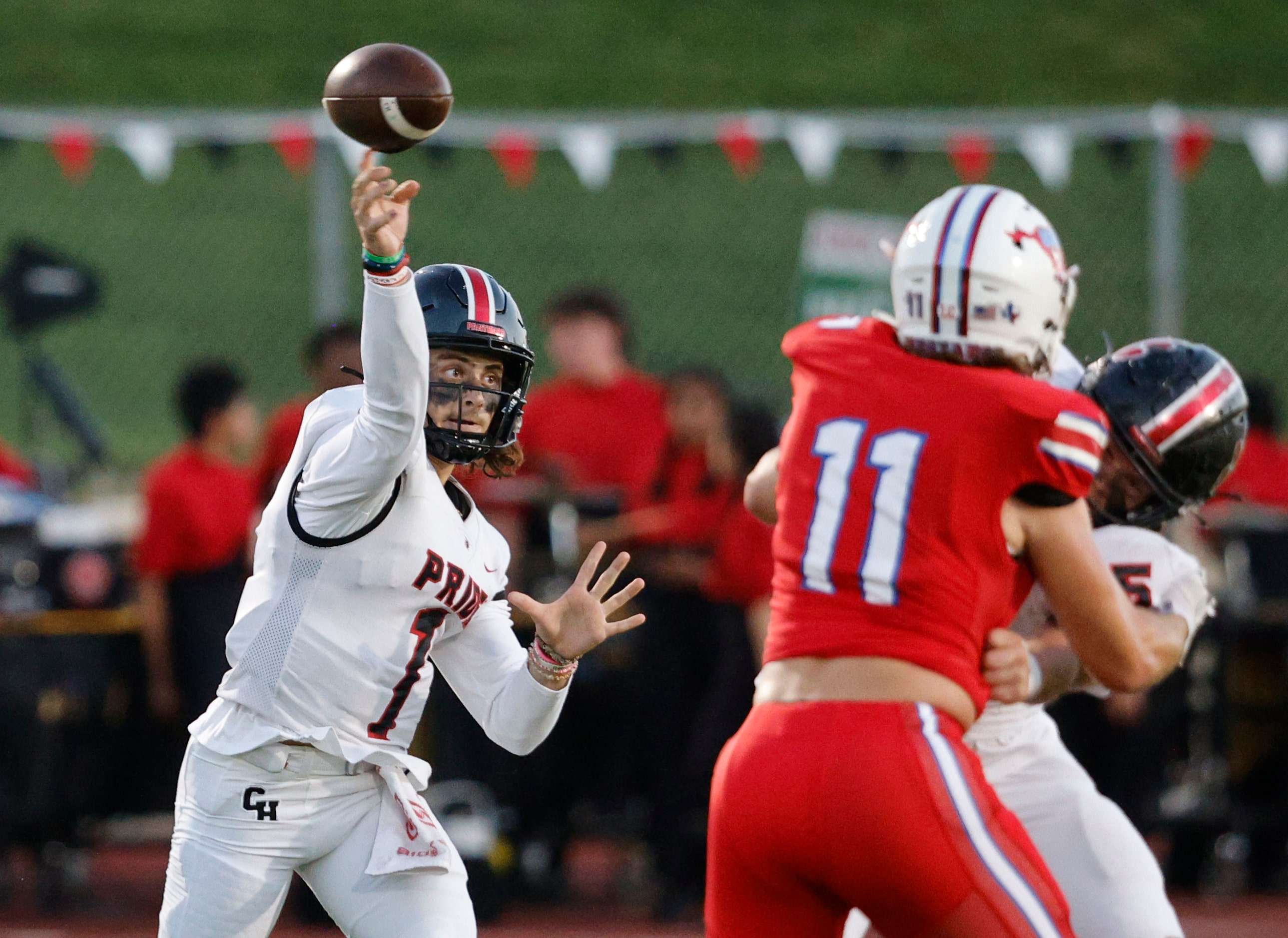 Colleyville Heritage's quarterback Luke Ullrich (1) passes under pressure from Grapevine's...