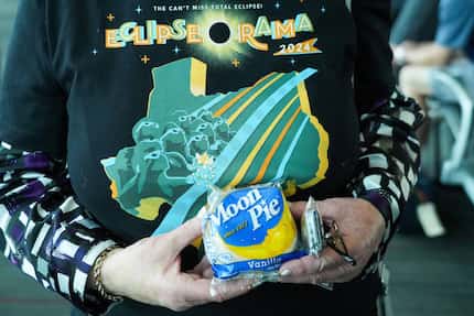 Bonnie Shatun holds a Moon Pie and wears a T-shirt promoting Eclipse-O-Rama before boarding...