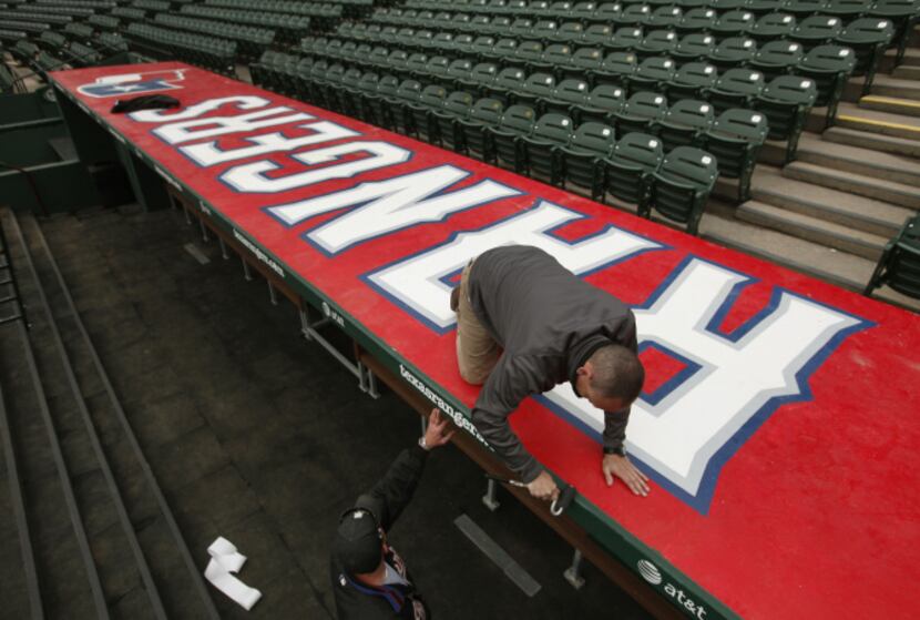 Lance Tucker and Dusty Keene put finishing touches on the Rangers’ dugout Thursday. The team...