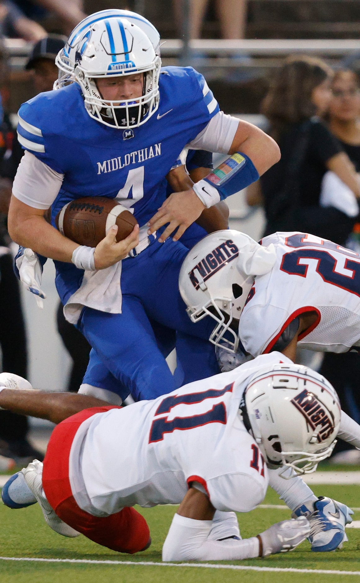 Midlothian's quarterback Beau Wendel (4) is tackled by Kimball's Juan-Milleon Aguilar (11)...