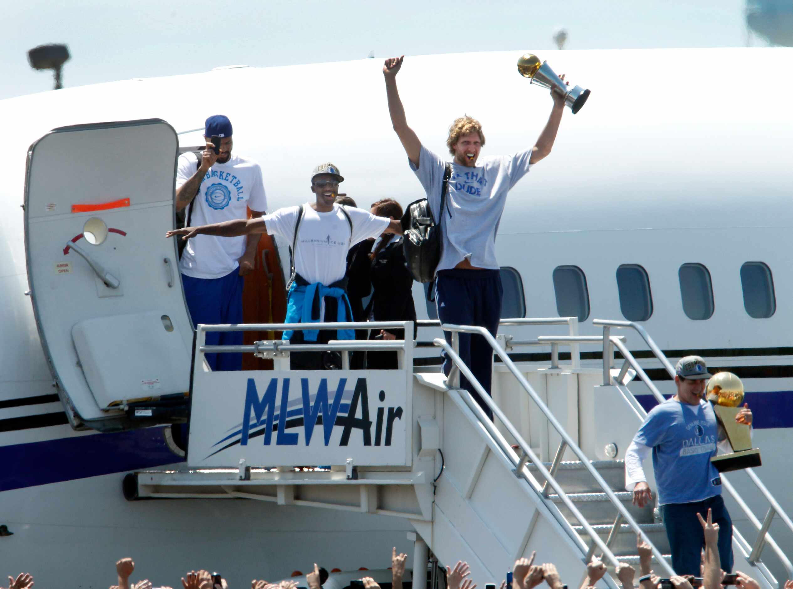 Dallas Mavericks owner Mark Cuban (bottom right) holds the Larry O'Brien NBA Championship...