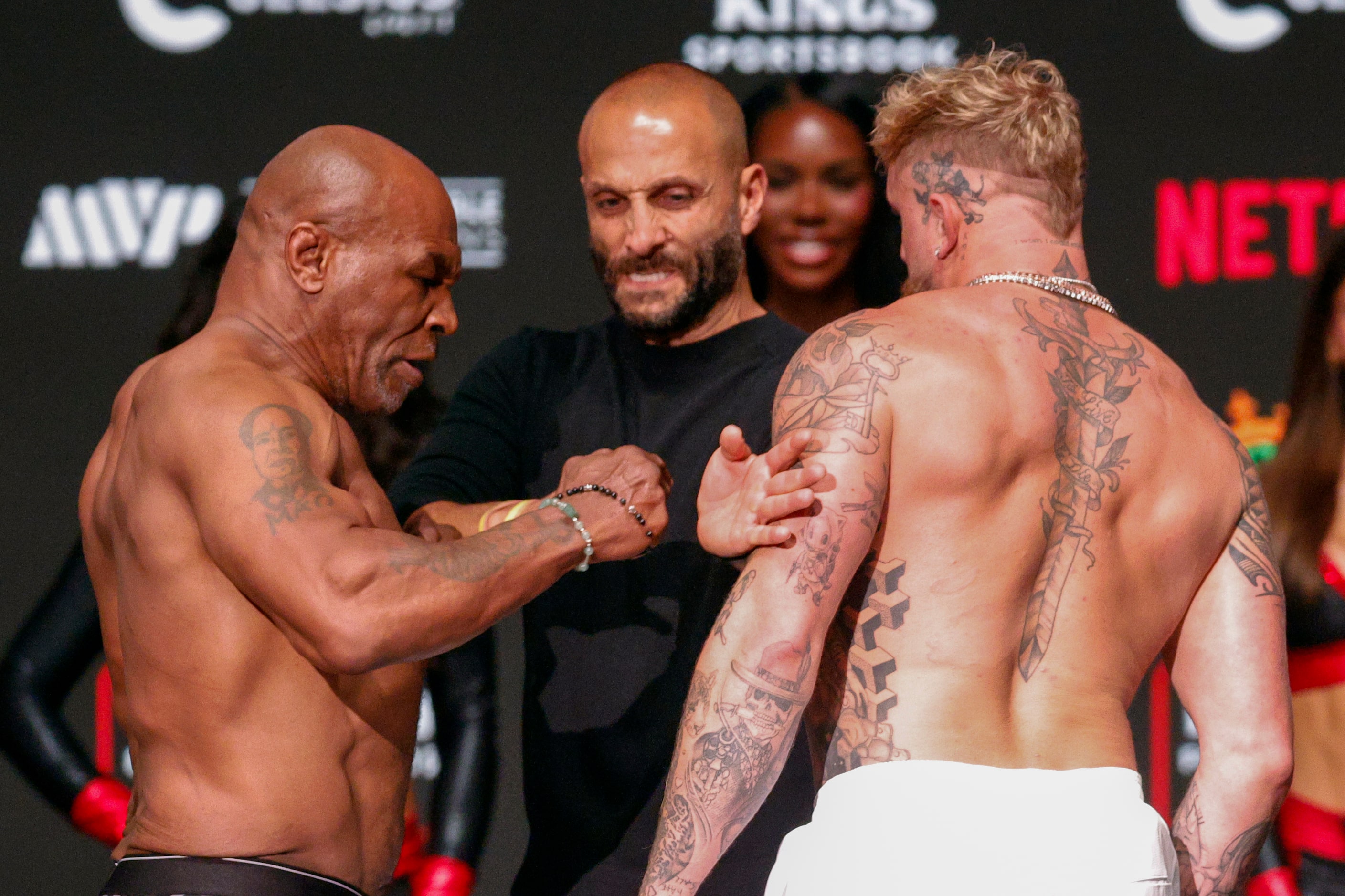 Mike Tyson slaps Jake Paul as they face-off during public weigh-ins ahead of their boxing...