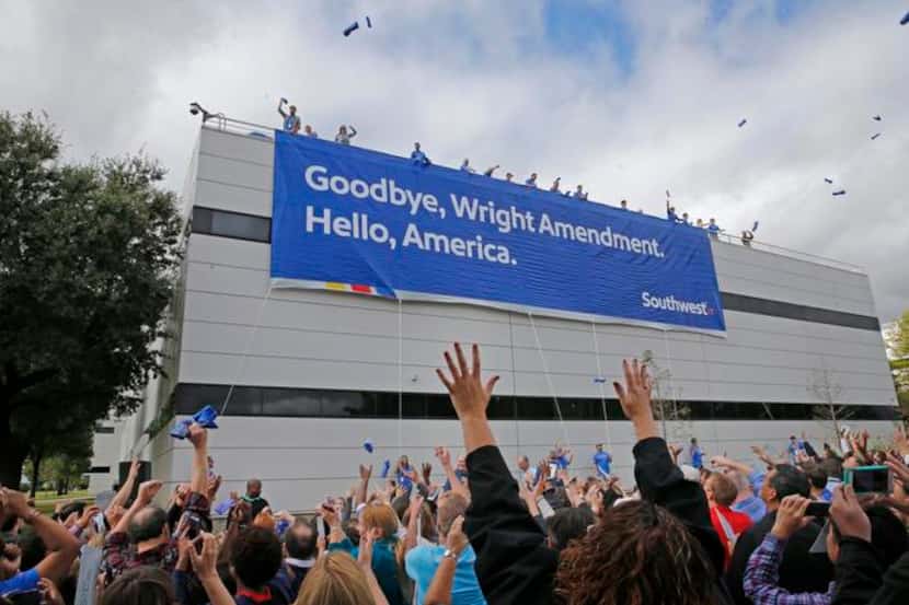 
Hundreds of Southwest Airlines employees cheer as T-shirts fly from the roof of the...