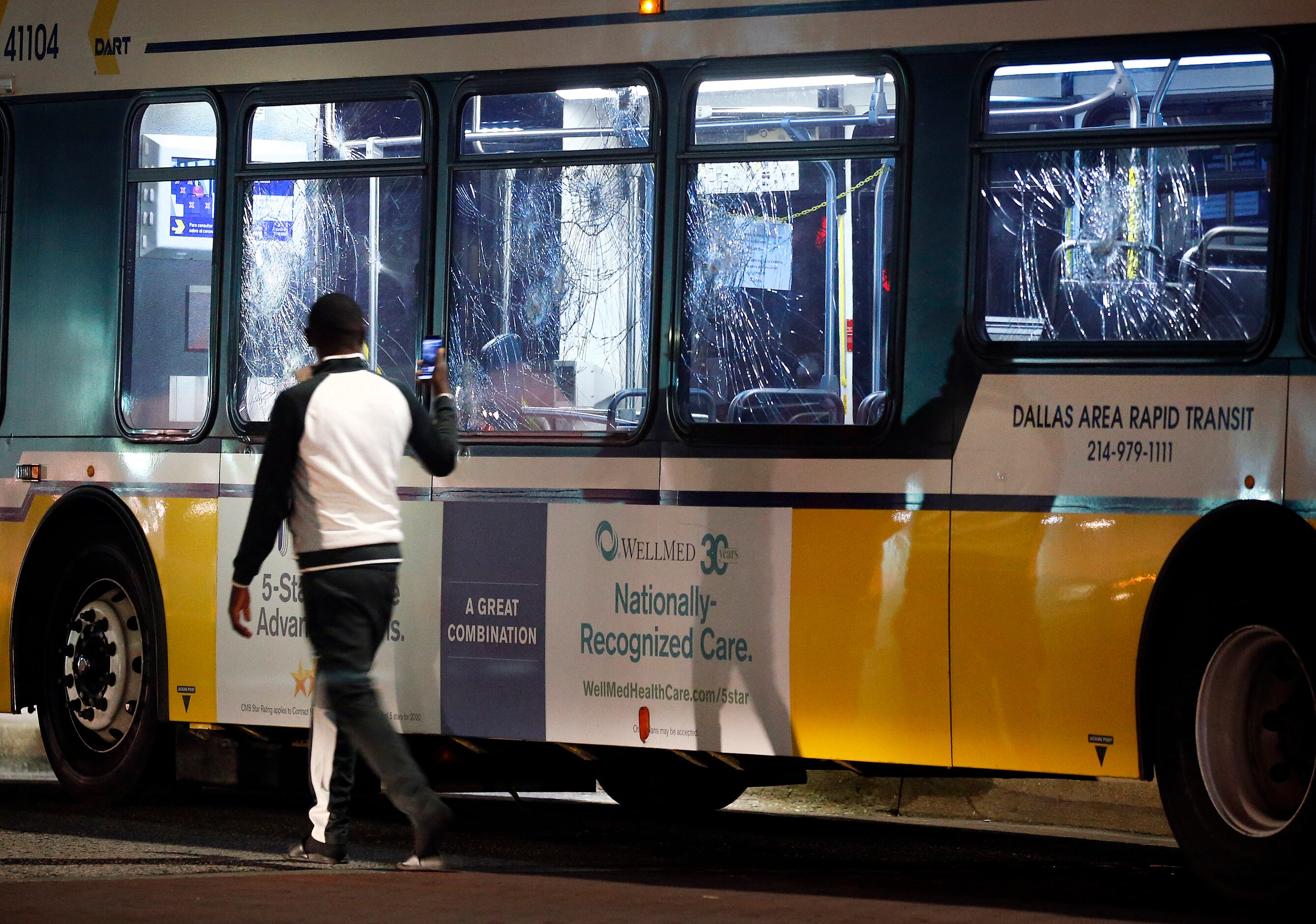 A protestor photographs a DART bus that was overrun by protestors and had the windows broken...