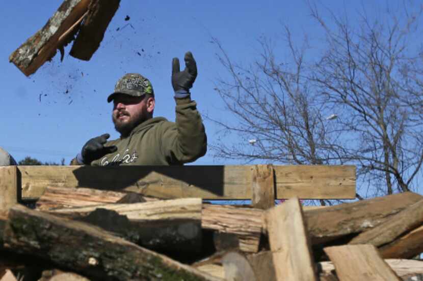 Lance Thompson unloads wood transported from Oklahoma at Personal Touch Tree Service on...