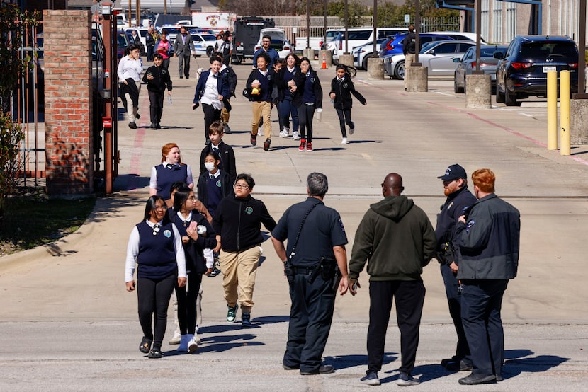 Students and faculty evacuate Pioneer Technology and Arts Academy to a nearby church to be...