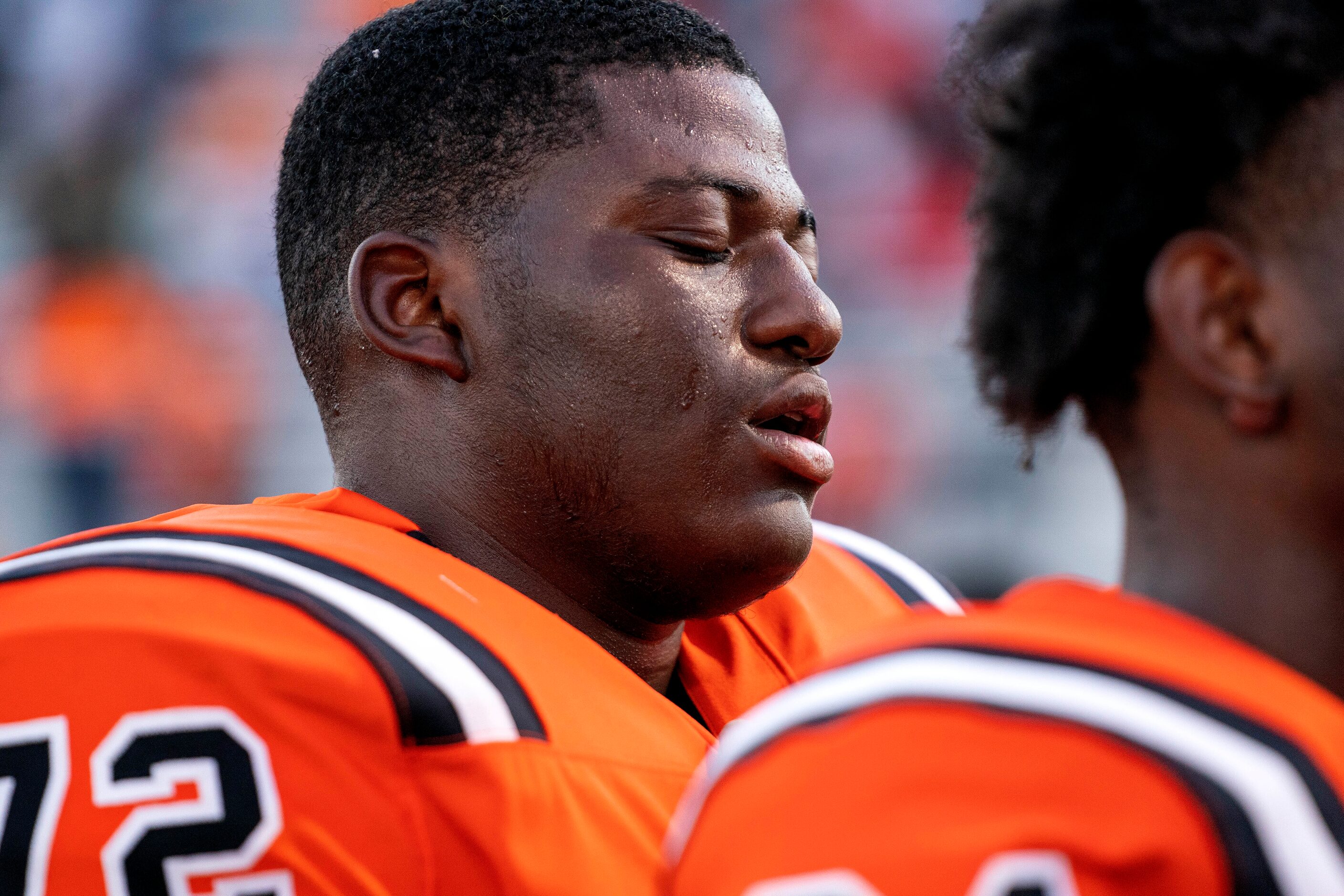 Lancaster senior offensive lineman Jeremiah Marks (72) closes his eyes during the playing of...