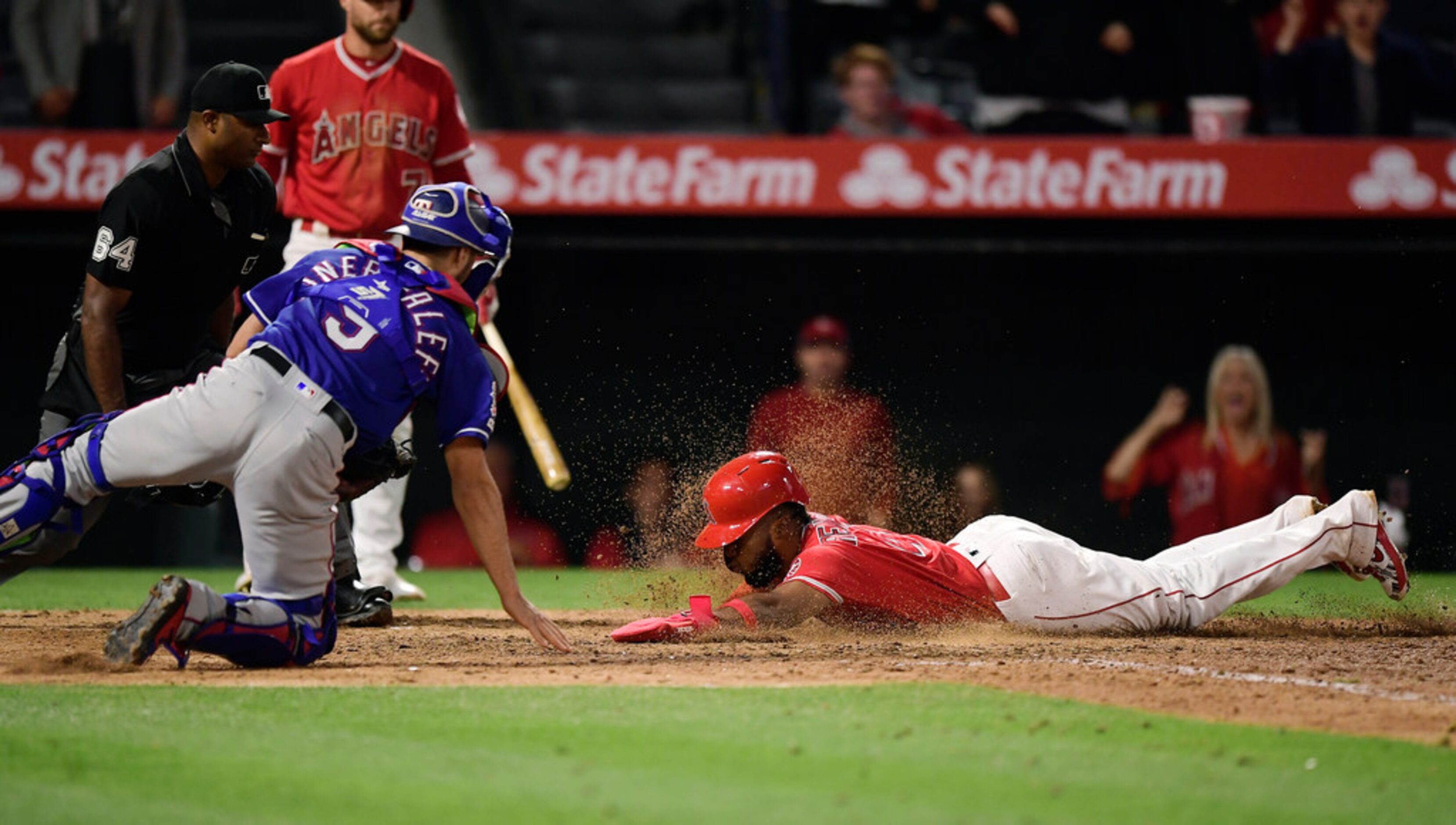 Los Angeles Angels' Luis Rengifo, right, scores on a double by Kole Calhoun as Texas Rangers...