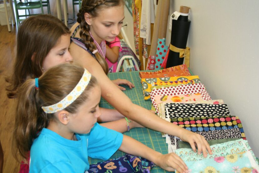 Elise Little, (front) Shannah Roberts and Erin McElhone choose fabrics during a summer...