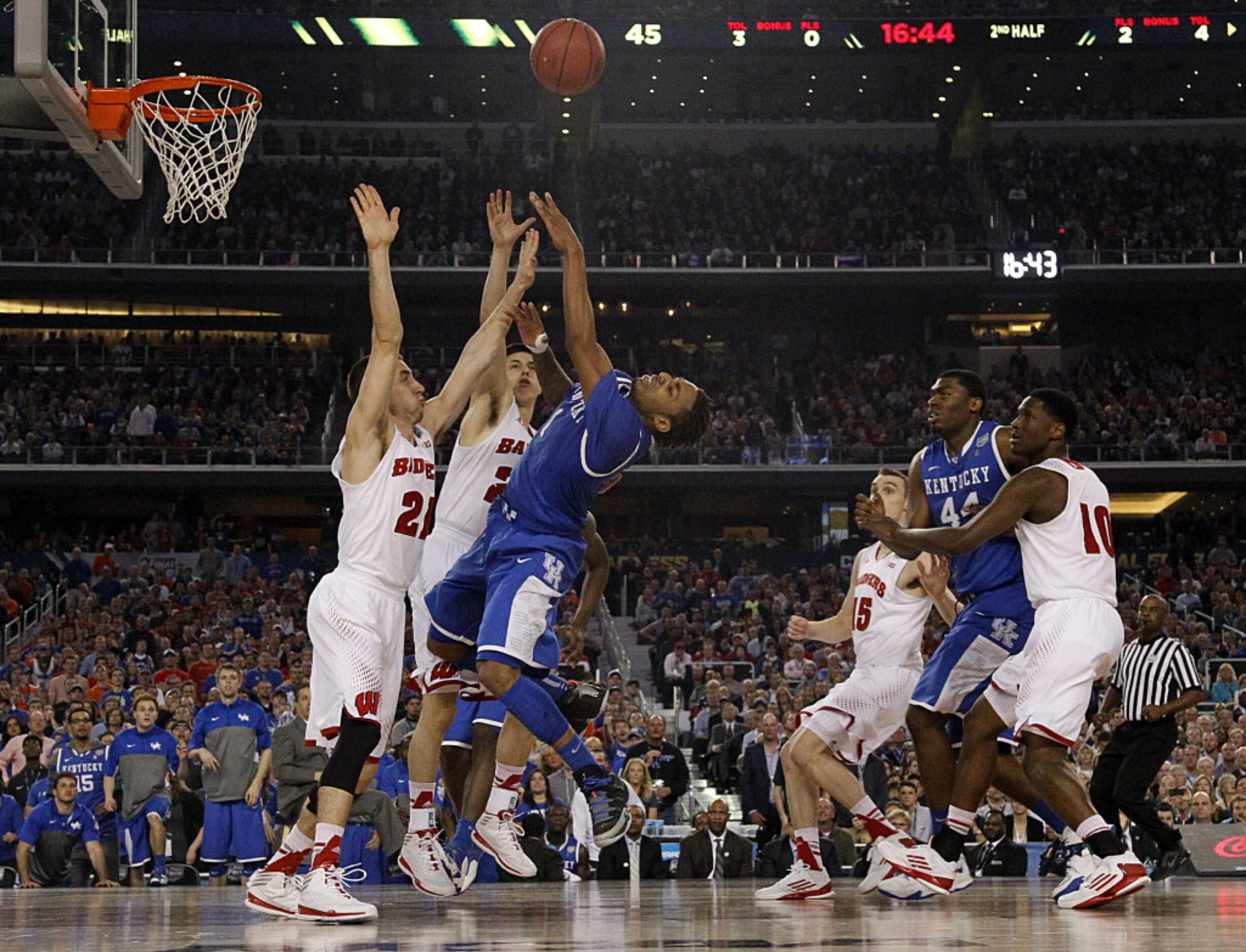 Kentucky Wildcats guard/forward James Young (1) is fouled by Wisconsin Badgers guard Josh...