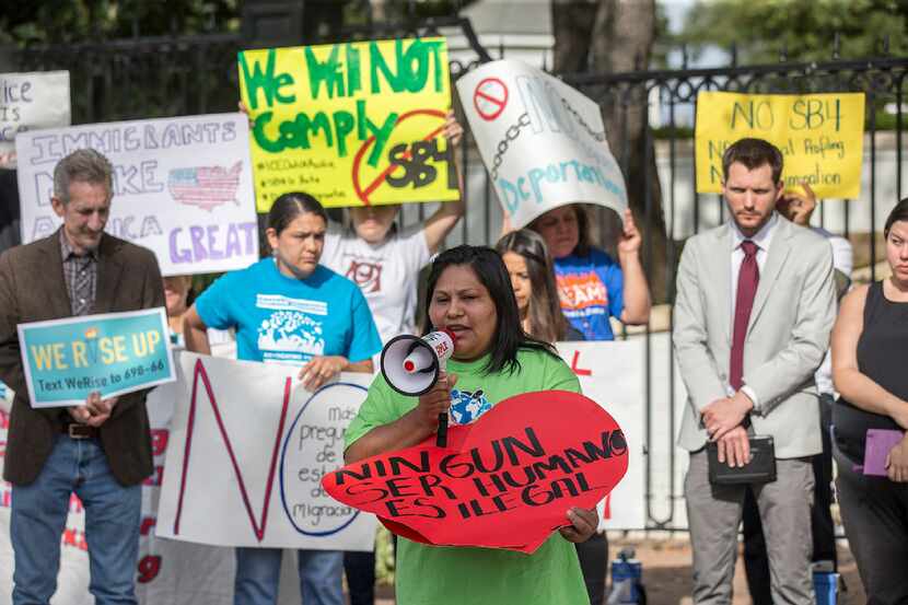 Maria Duque speaks during a protest outside of the Texas Governor's Mansion in Austin,...