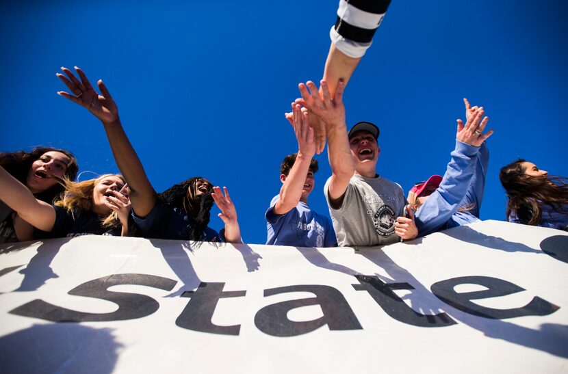 Flower Mound fans get high-fives from their soccer players after a 3-2 win in a UIL...