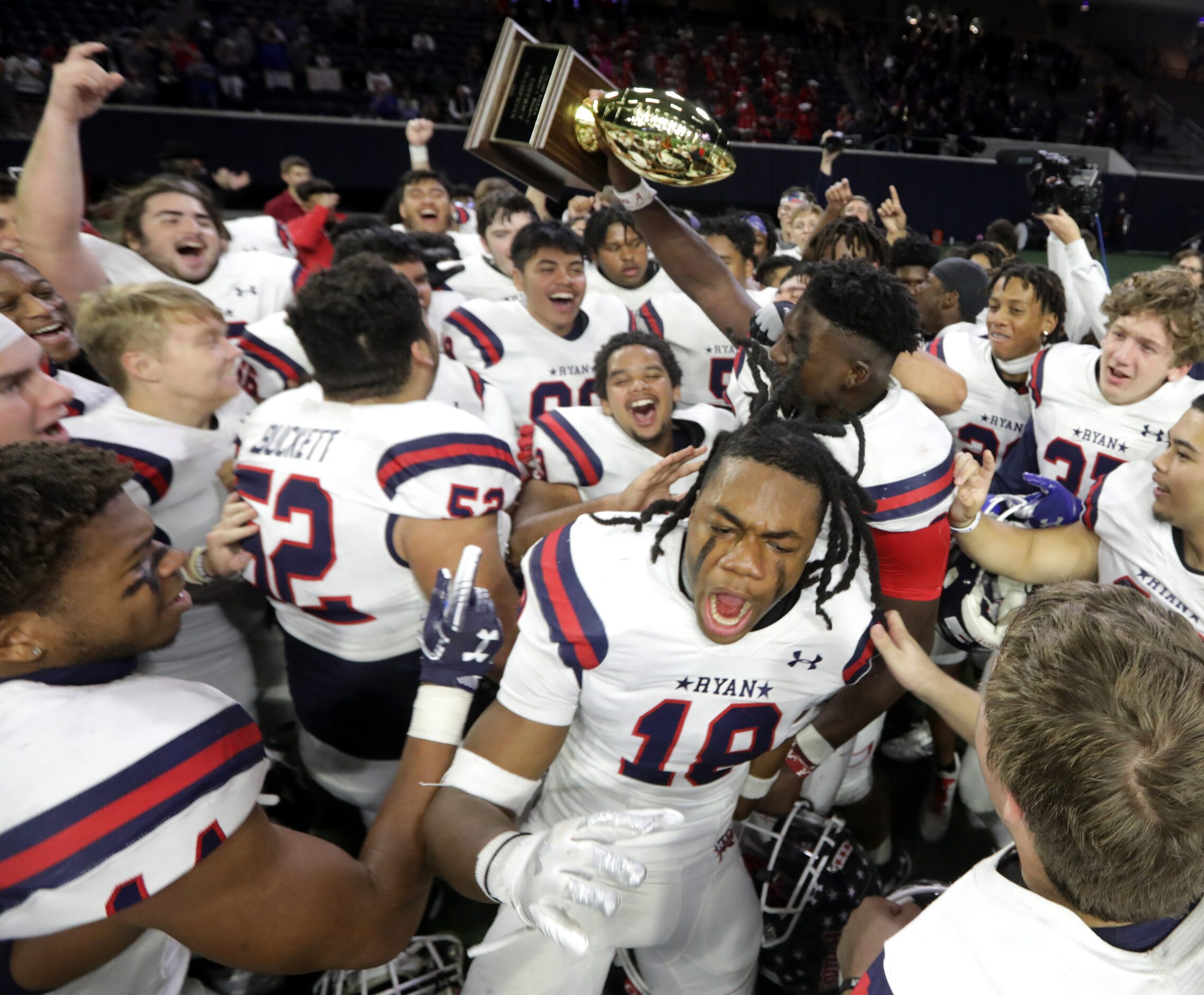 The Denton Ryan High School team celebrates after winning a football game against Frisco...