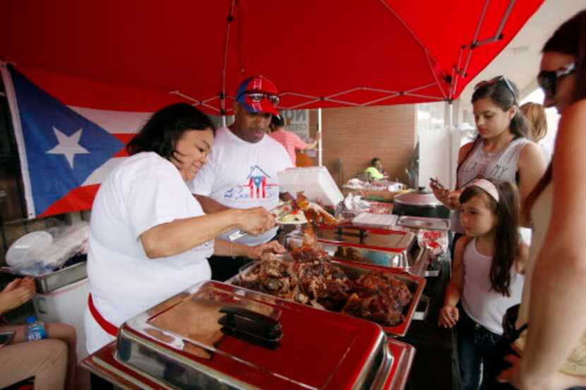 Bernice Castro (izq.) y su esposo Ismael sirven comida tradicional puertorriqueña durante un...