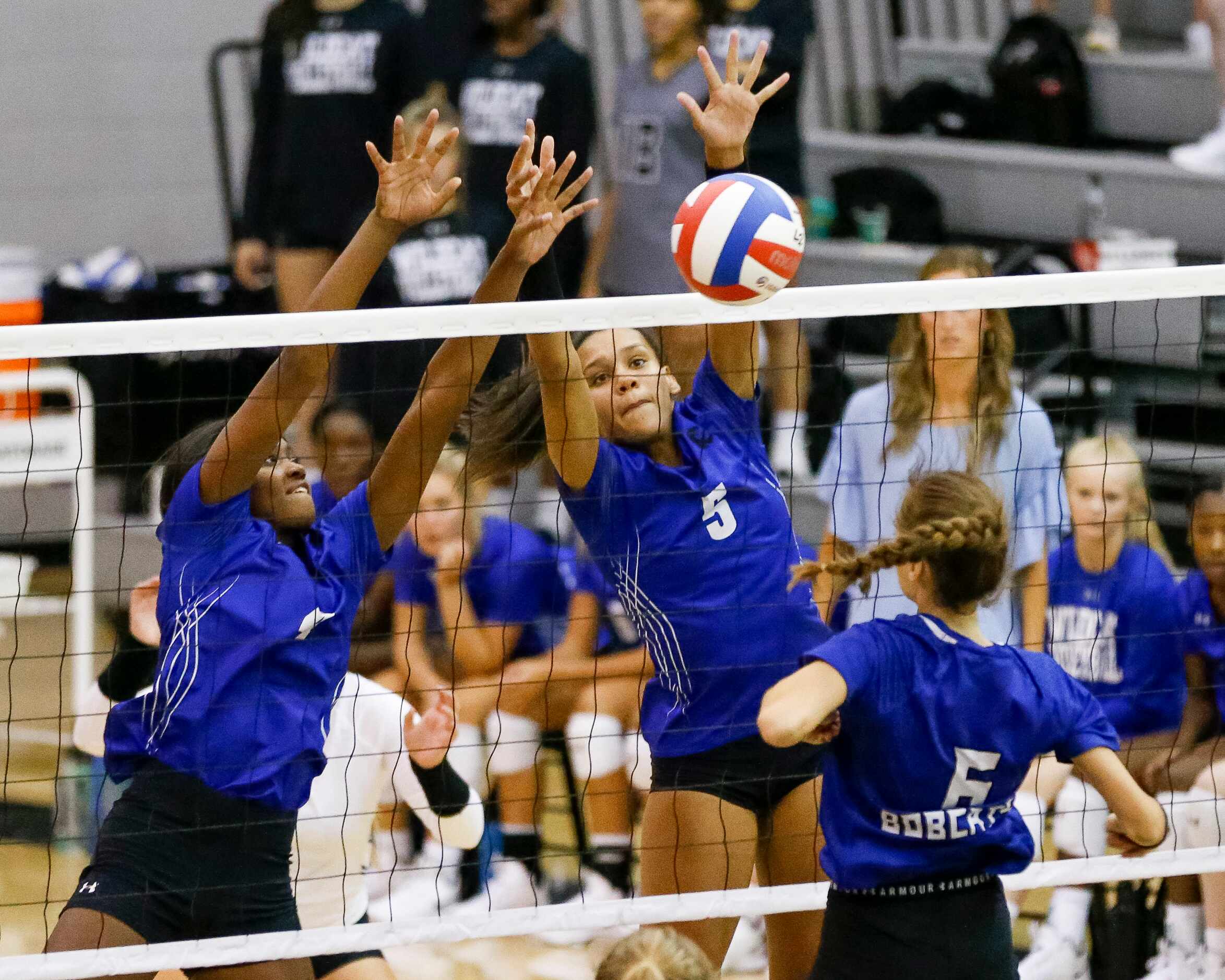 Denton Guyer middle blocker London Hunt (4) and outside hitter Kyndal Stowers (5) block the...