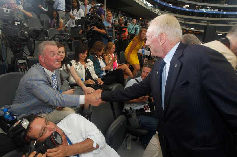 Stephen Jones shakes hands with his father, Dallas Cowboys owner Jerry Jones at AT&T Stadium...