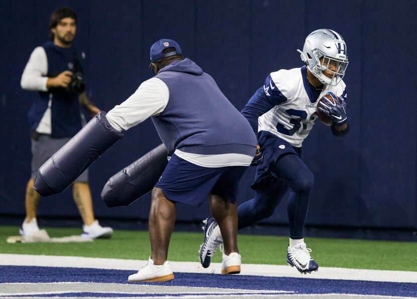 Dallas Cowboys running back Tony Pollard (36) runs a drill with running backs coach Gary...