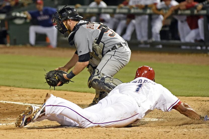 Texas Rangers shortstop Elvis Andrus (1) slides safely into home in front of Detroit Tigers...