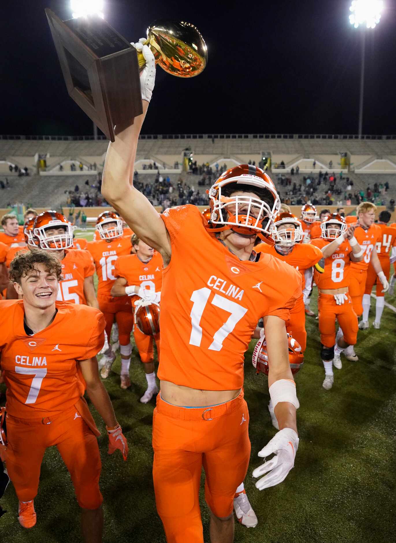 Celina wide receiver DJ Dell'Anno (17) lifts the game trophy in celebration after a 42-24...