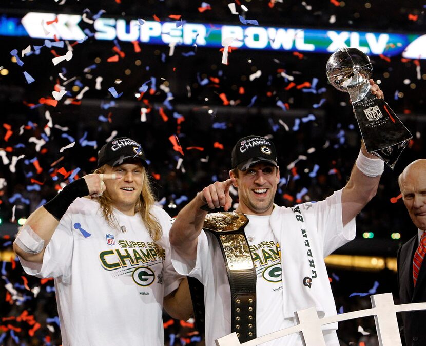 Green Bay Packers MVP quarterback Aaron Rodgers (12) hoists the Super Bowl trophy with...