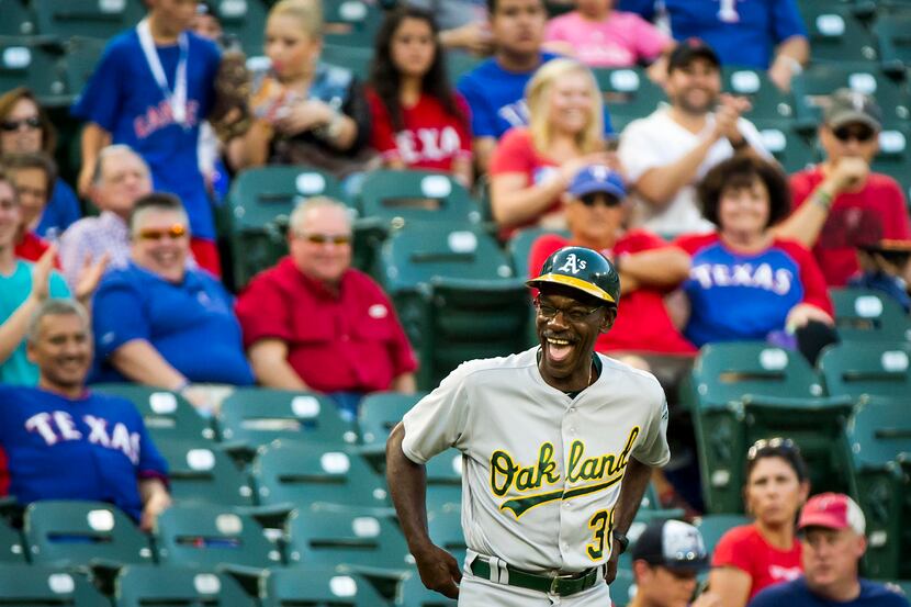 Oakland Athletics third base coach Ron Washington laughs as he takes the field for the first...
