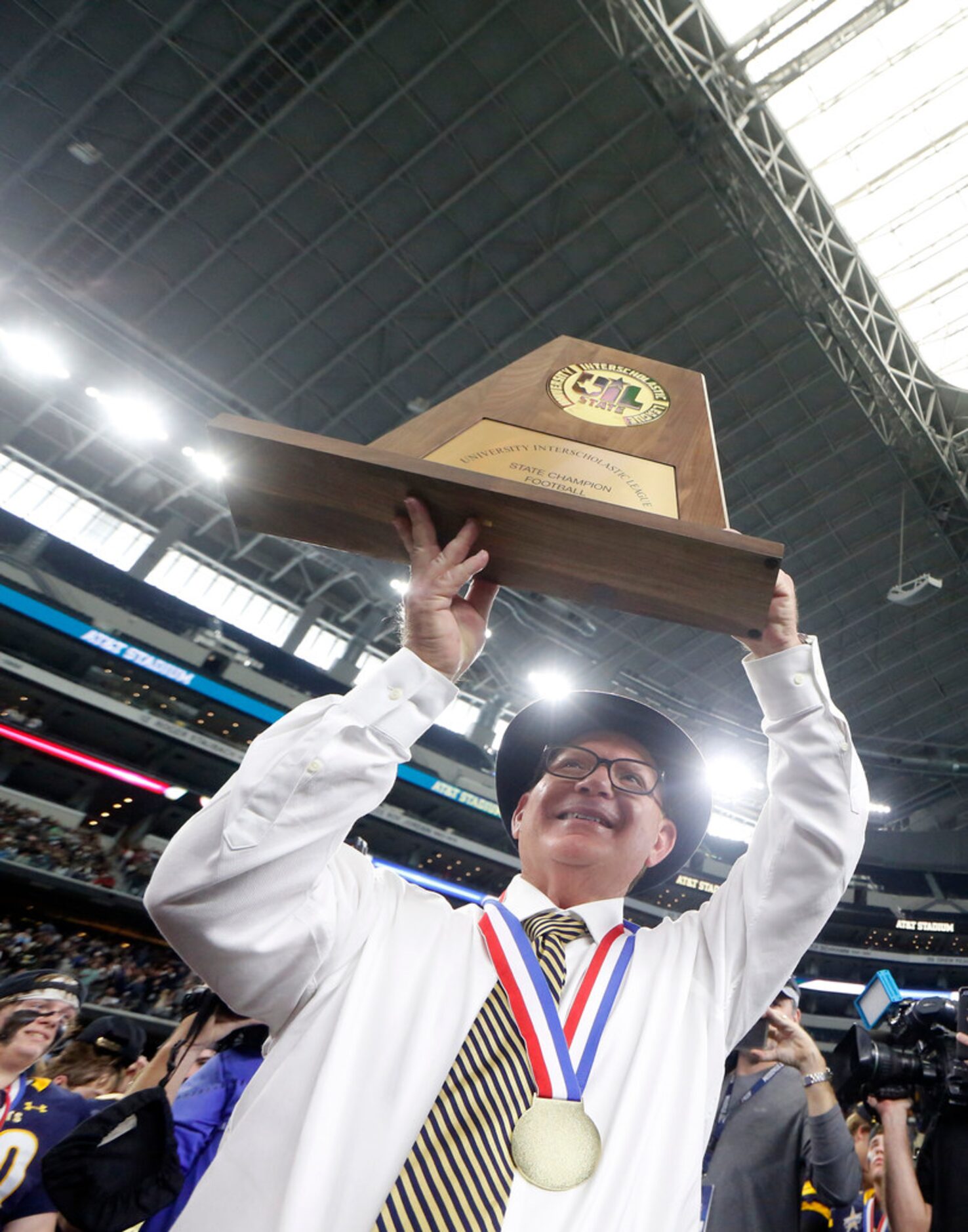 Highland Park's Head coach Randy Allen holds up the Class 5A Division I football state...