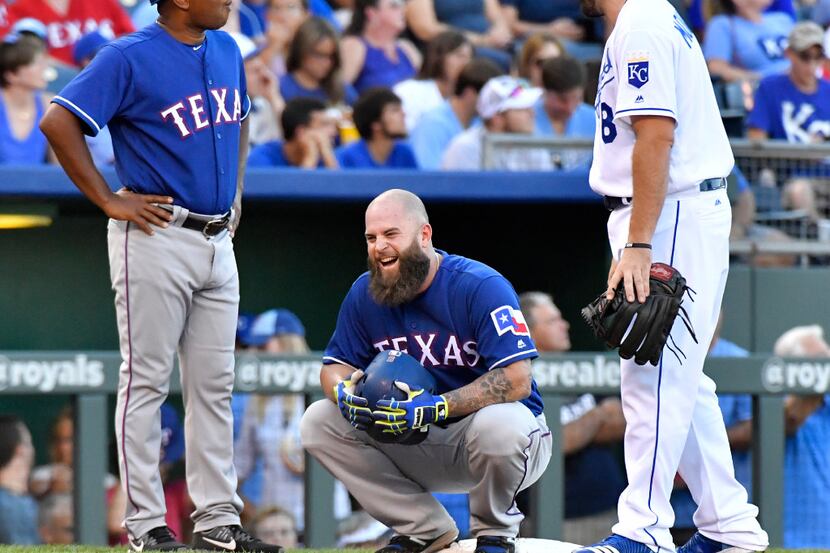Texas Rangers' Mike Napoli laughs with Kansas City Royals third baseman Mike Moustakas while...