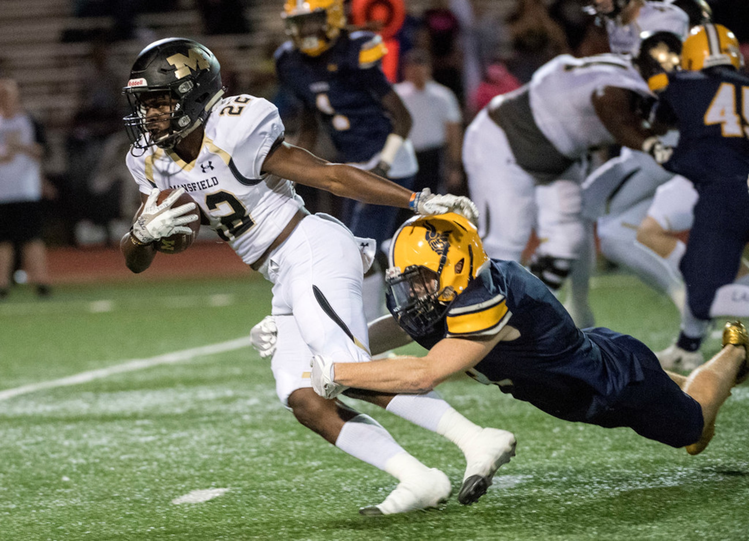 Mansfield senior running back KJ Hawkins (22) is brought down from behind by Arlington Lamar...