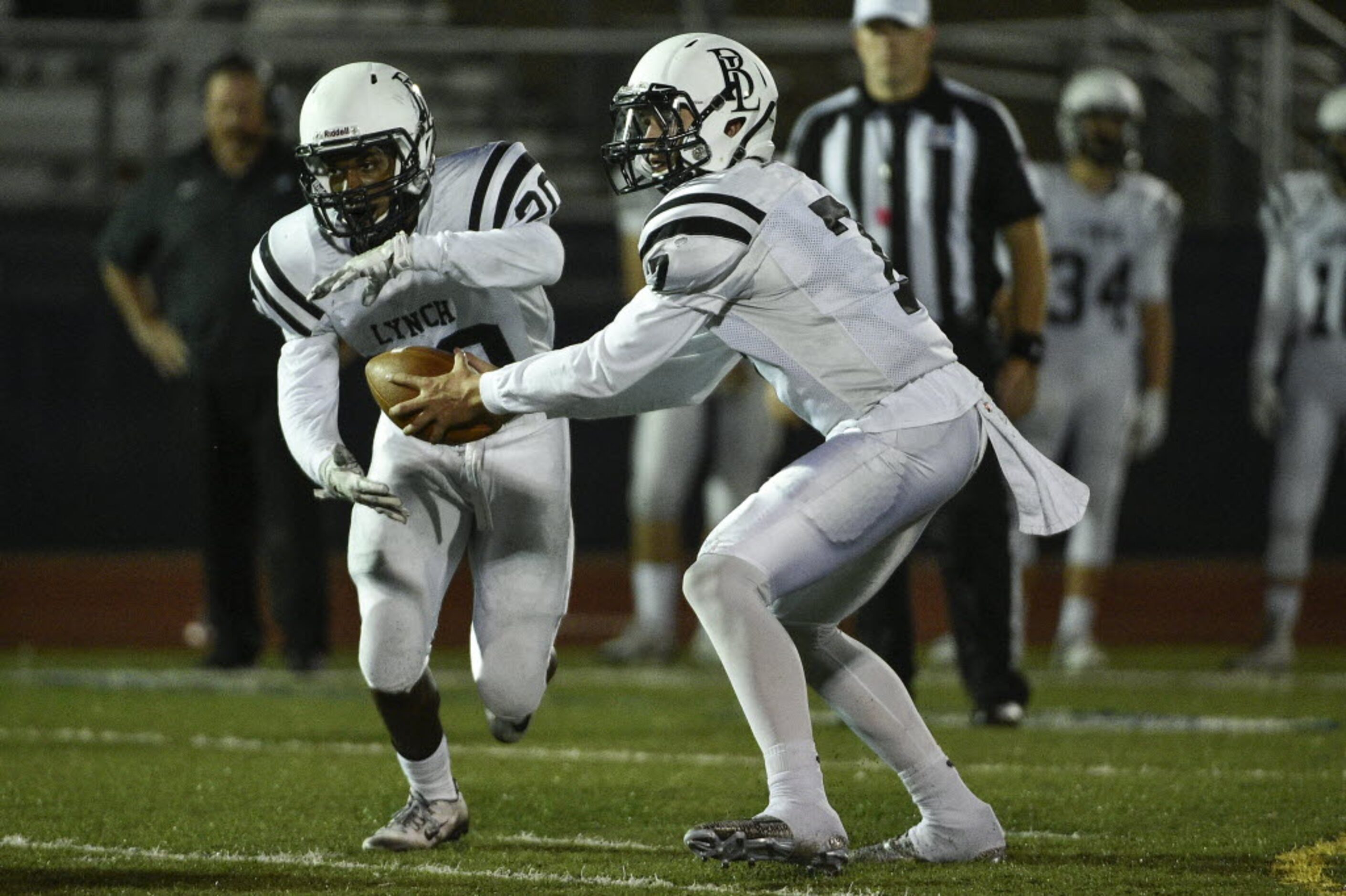 Bishop Lynch running back Jermaine Mask (20) takes a handoff from quarterback Tristan Smith...