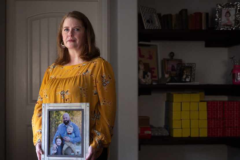 Katie McCoy poses Nov. 4, 2021, at her home in Forney with a photo of Dallas police Sgt....