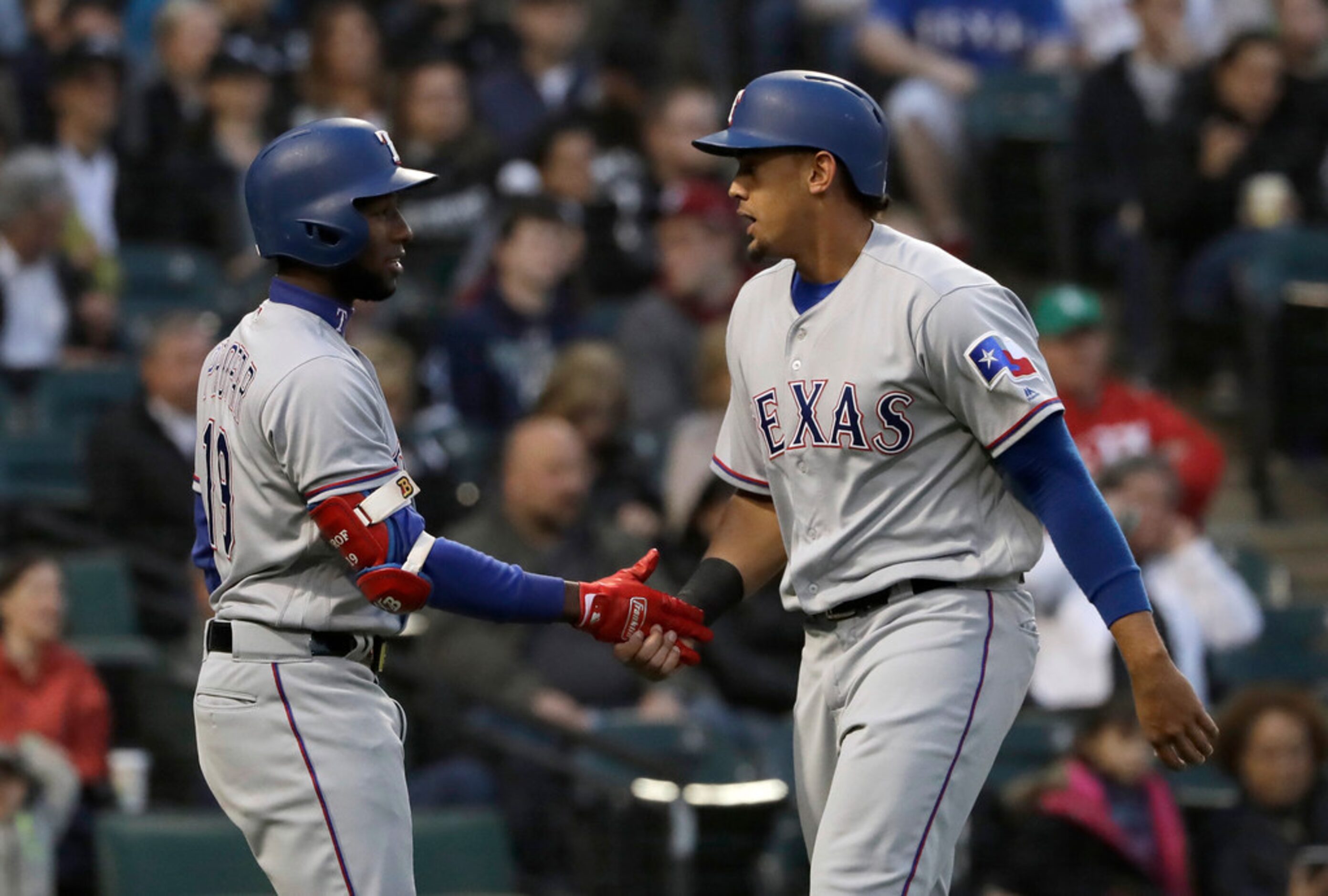 Texas Rangers' Ronald Guzman, right, celebrates with Jurickson Profar after scoring on a...