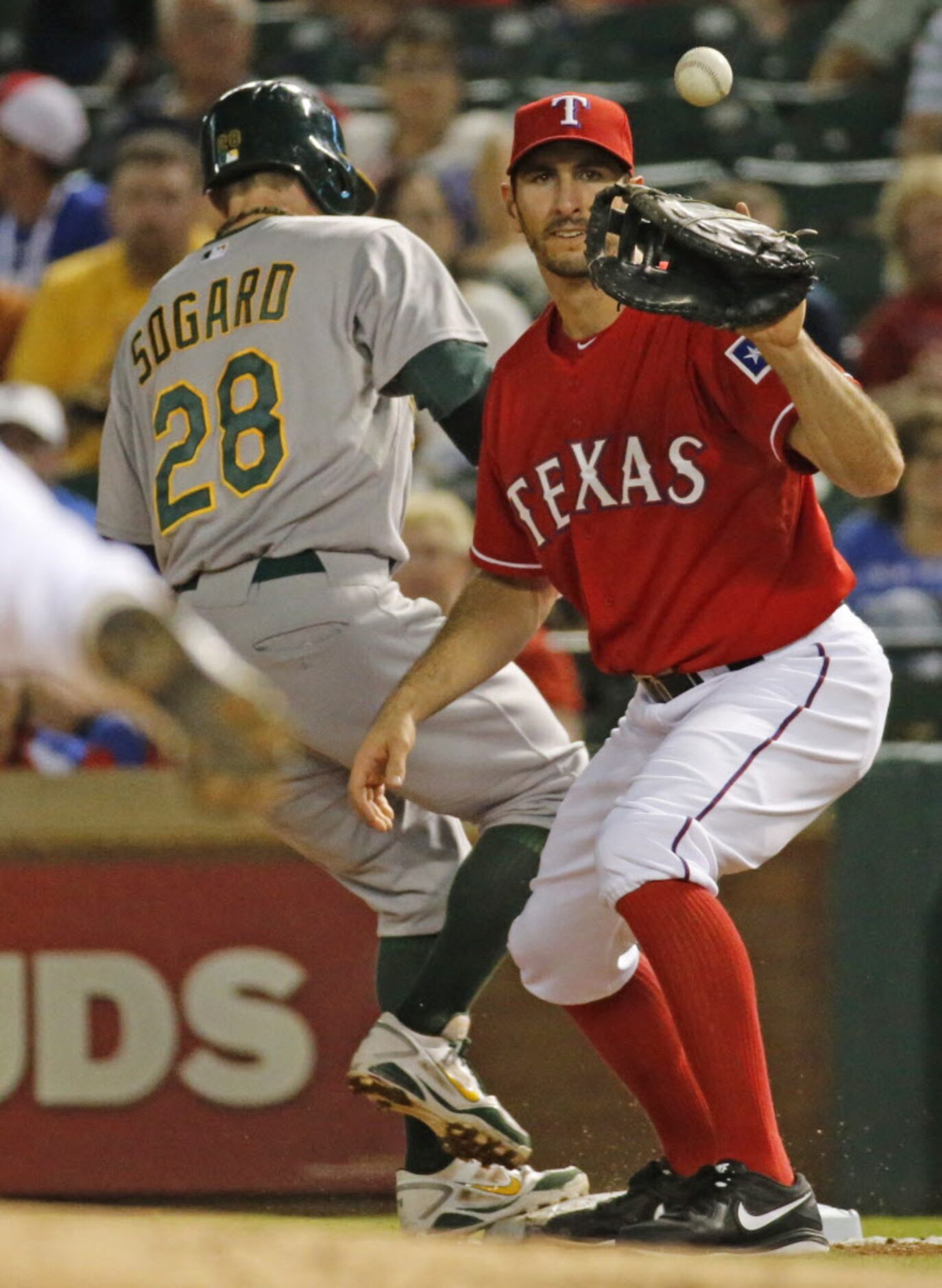 Texas first baseman Adam Rosales takes the pickoff throw, as Oakland's Eric Sogard gets back...