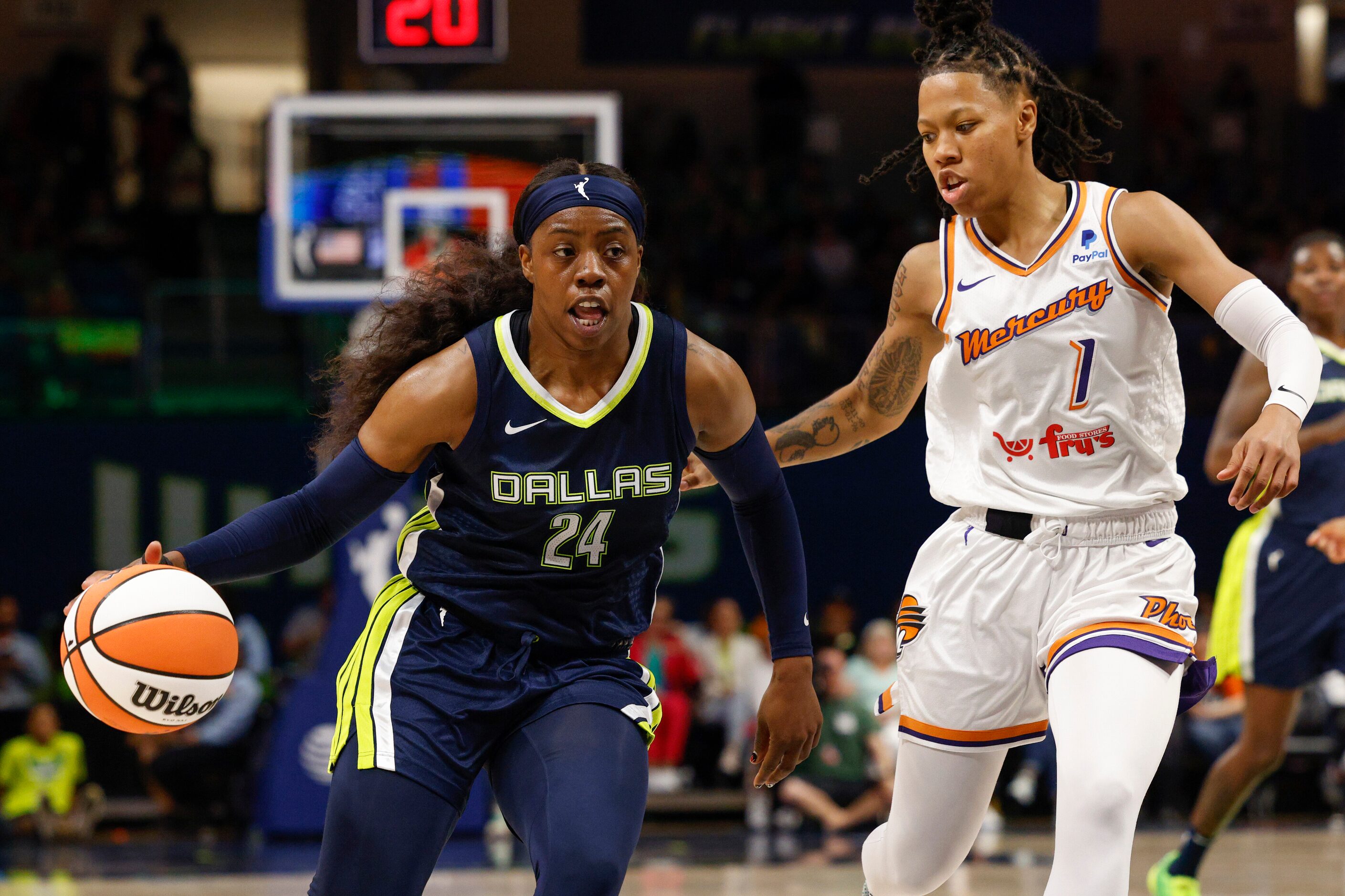 Dallas Wings guard Arike Ogunbowale (24) dribbles up the court alongside Phoenix Mercury...