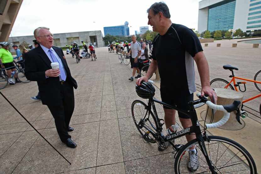 Mayor Mike Rawlings is greeted by John Crawford, president of Downtown Dallas Inc., (left)...