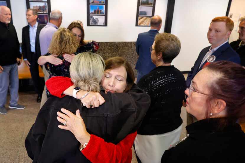 Loren Adair Smith (facing) receives a hug from Cheryl Pangburn after speaking about the...