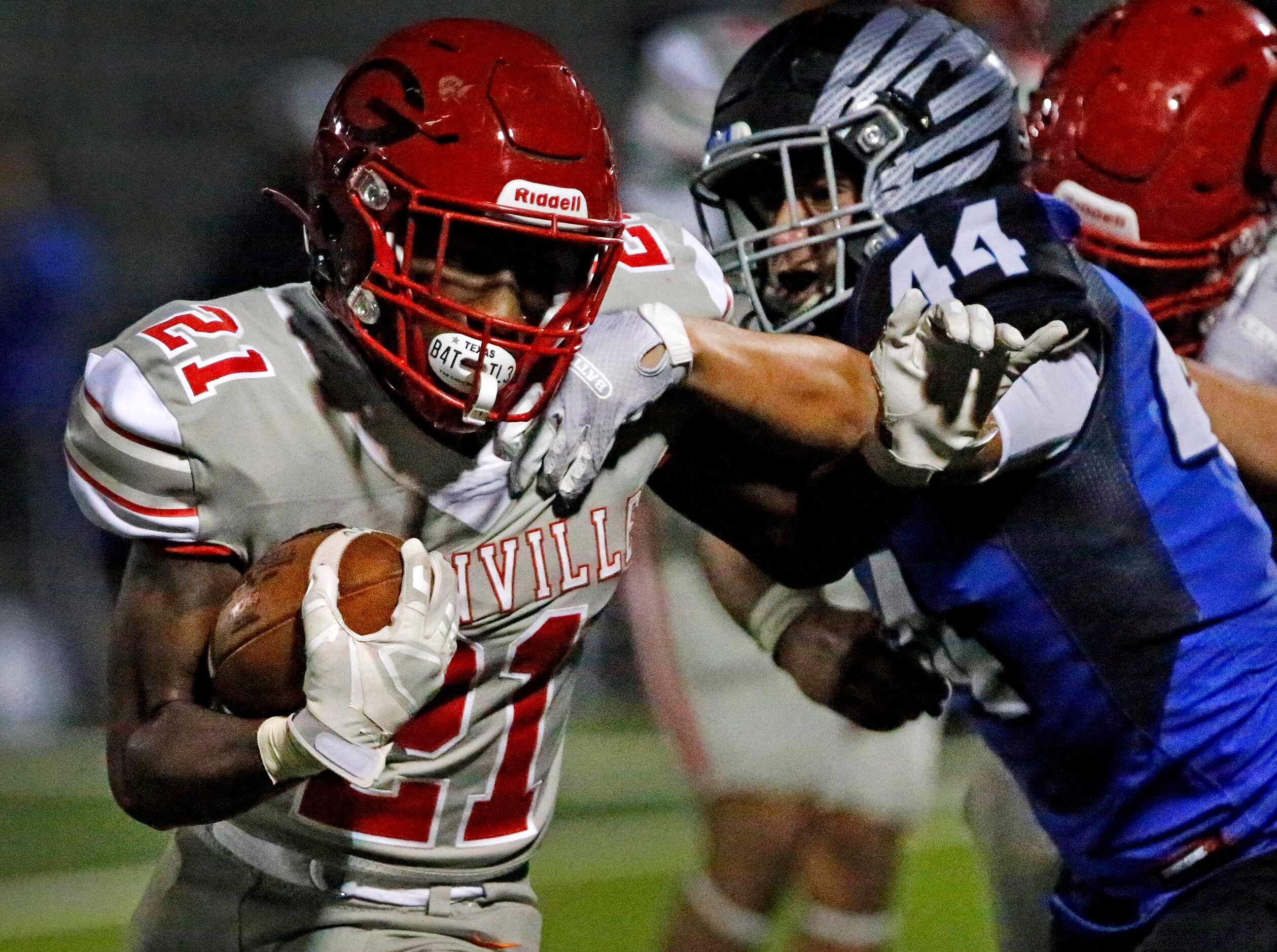 Greenville High School running back Ottugas Johnson (21) is slowed down by North Forney High...