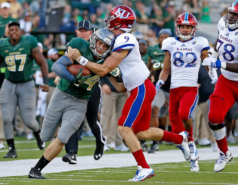 Baylor linebacker Clay Johnston (44) is tackled by Kansas quarterback Carter Stanley (9)...