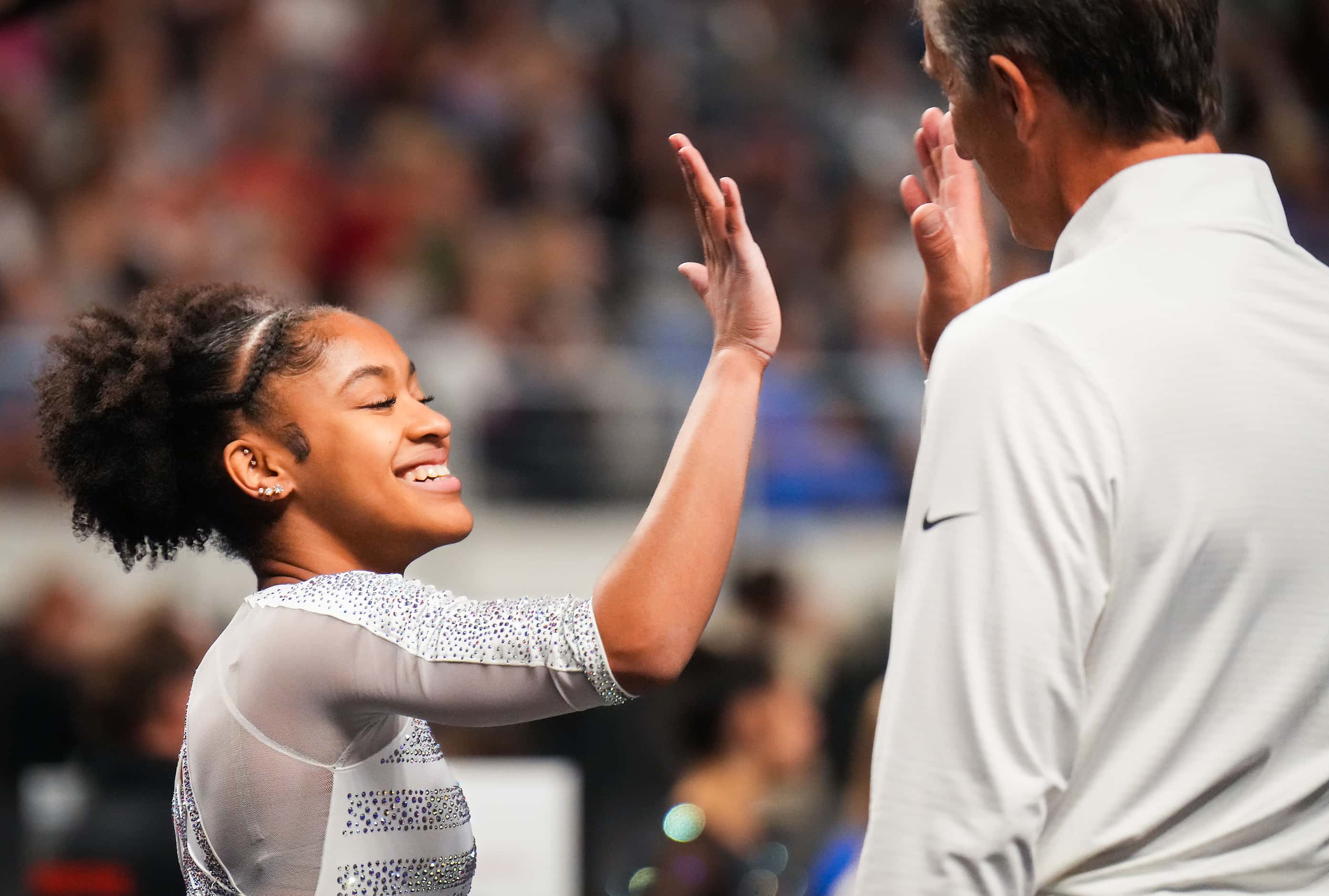 Skye Blakely celebrates with coach Yevgeny Marchenko after she competed on the balance beam...