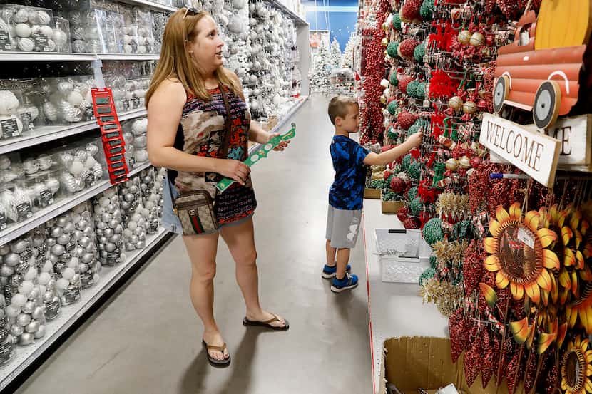 Jennifer Bodnyk (izq.) y su hijo Ford, de 8 años, revisan la oferta de items navideños en At...