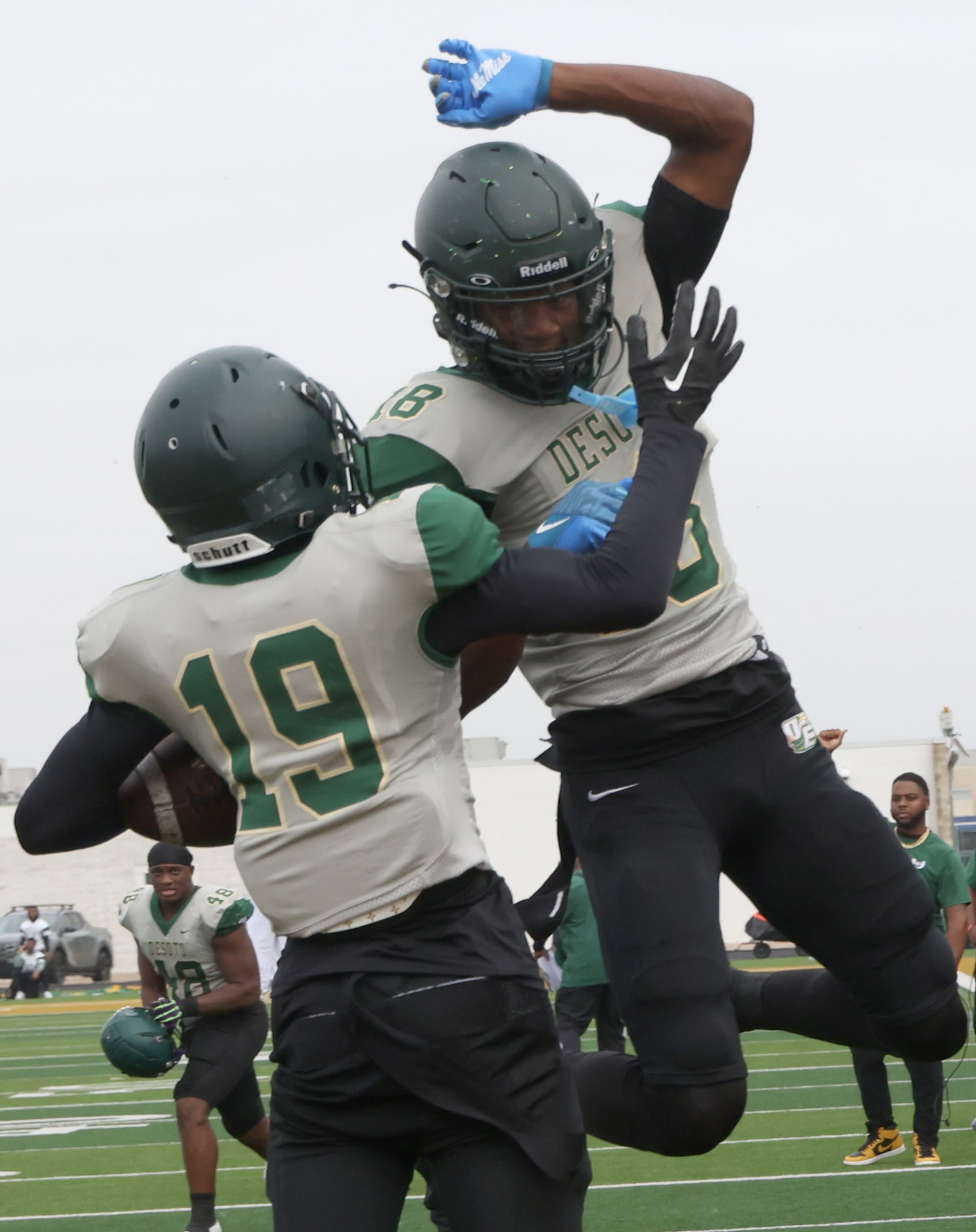 DeSoto Eagles receiver Ethan Feaster (18), top, skies as he congratulates receiver Kristoff...