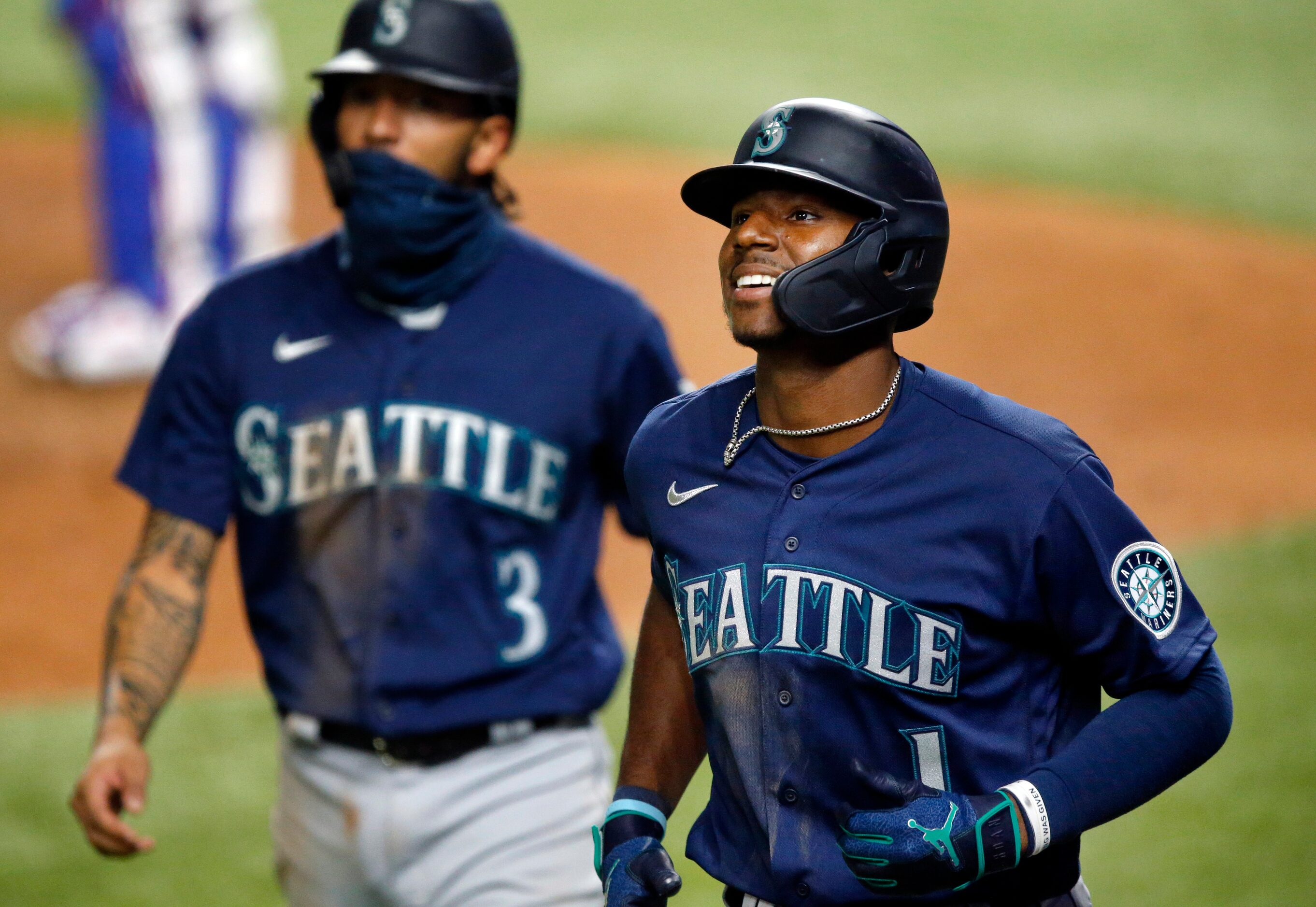 Seattle Mariners Kyle Lewis (1) smiles as he returns to the dugout after a three run homer...