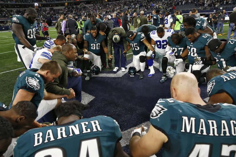 A prayer circle at the end of Dallas Cowboys and Philadelphia Eagles game  at AT&T Stadium...