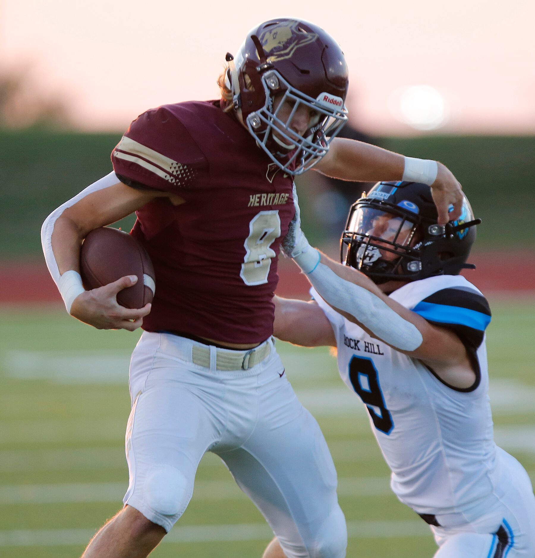 Heritage High School wide receiver Bryce Gilchrist (8) stiff arms Rock Hill High School...