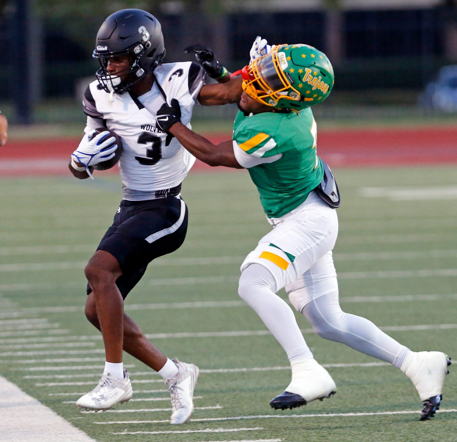 Mansfield Timberview’s Cameron Bates (3) straight-arms a Newman Smith defender, as he is...